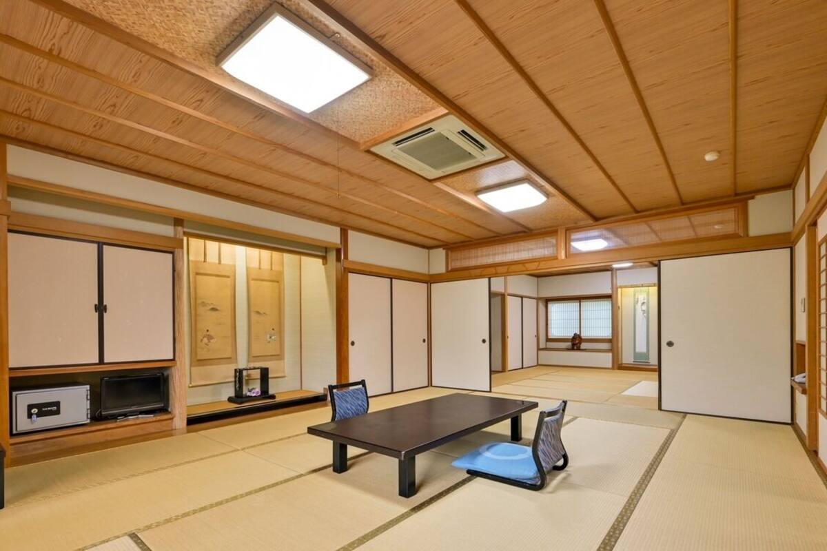 A traditional Japanese room with tatami flooring, a low table, and sliding doors.