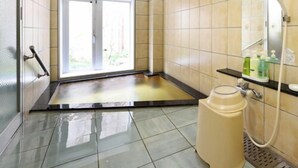 A bathroom with a shower, a sink, and a toilet.