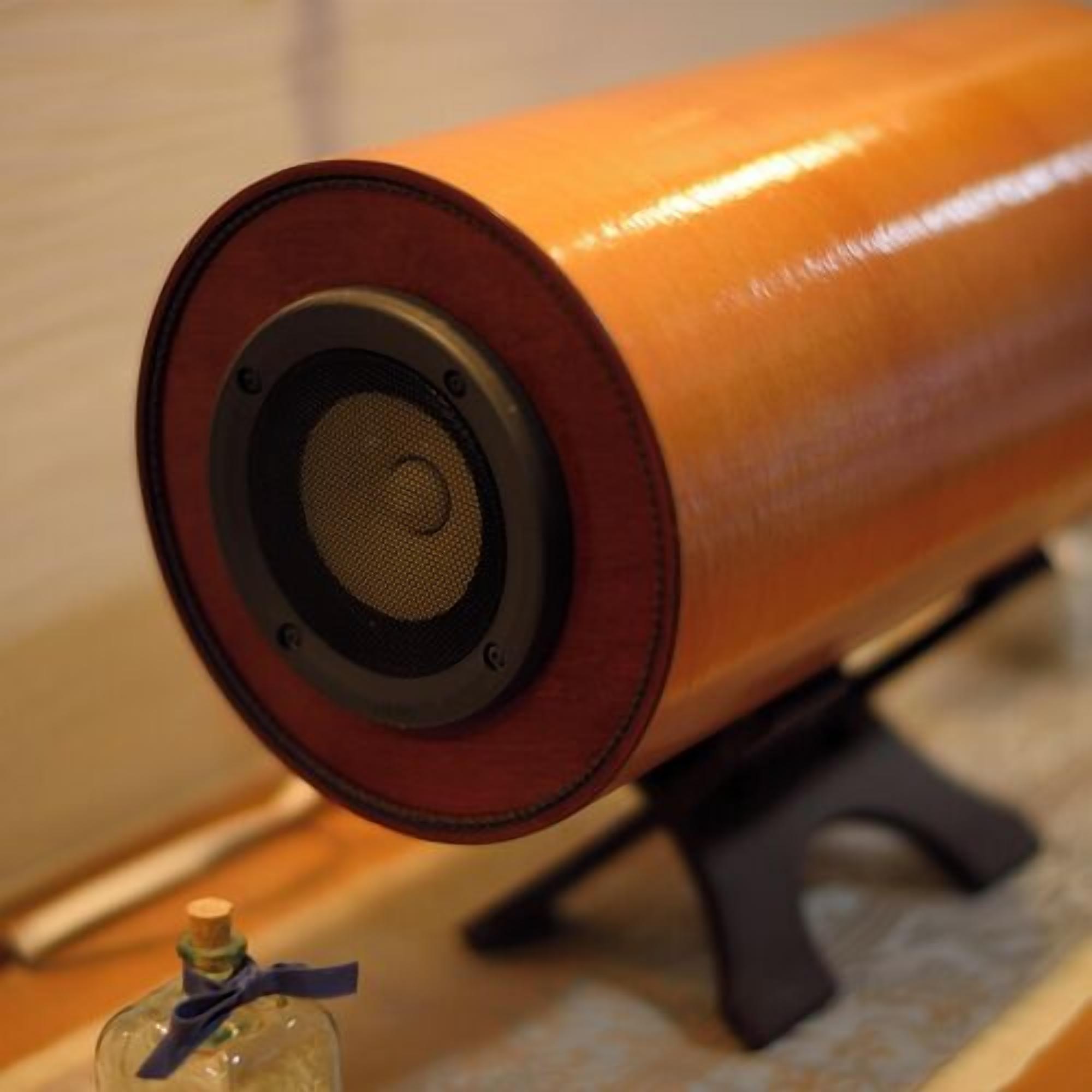 A cylindrical object with a speaker grille, possibly a decorative item, on a stand.