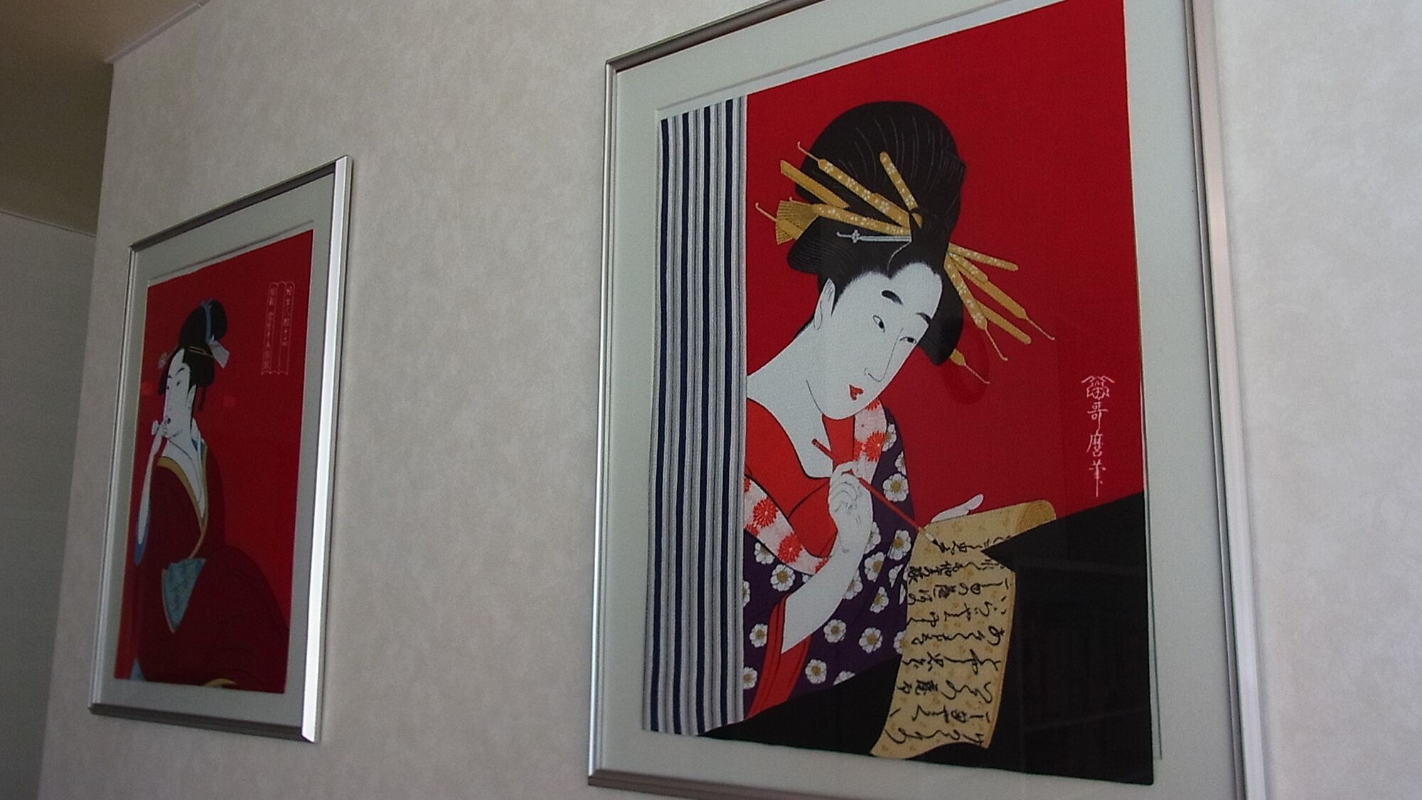 Two framed artworks on a wall.