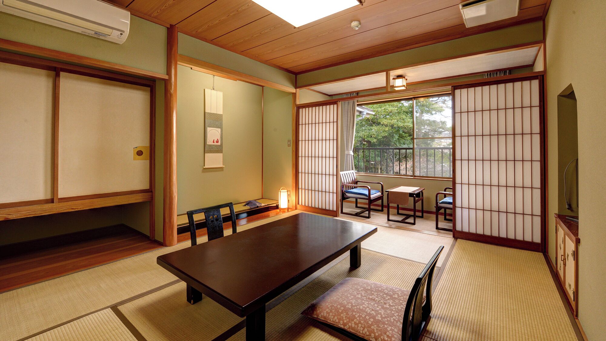 Una habitación japonesa tradicional con suelo de tatami, una mesa baja y puertas correderas.