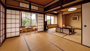 A traditional Japanese room with tatami flooring, sliding doors, a low table with cushions, and a television. - Kaihinso Kamakura (Kamakura)