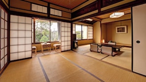 A traditional Japanese room with tatami flooring, sliding doors, a low table with cushions, and a television. - Kaihinso Kamakura (Kamakura)