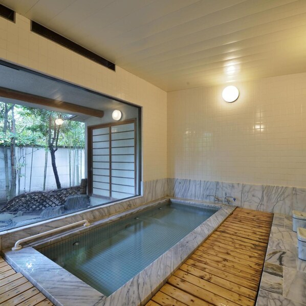 A spa area with a hot tub, wooden deck, and a view of greenery outside. - Kaihinso Kamakura (Kamakura)