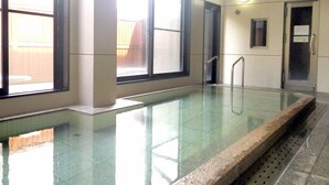 A swimming pool with clear glass walls, a tiled floor, and a metal handrail. - Village Azumino (Azumino)