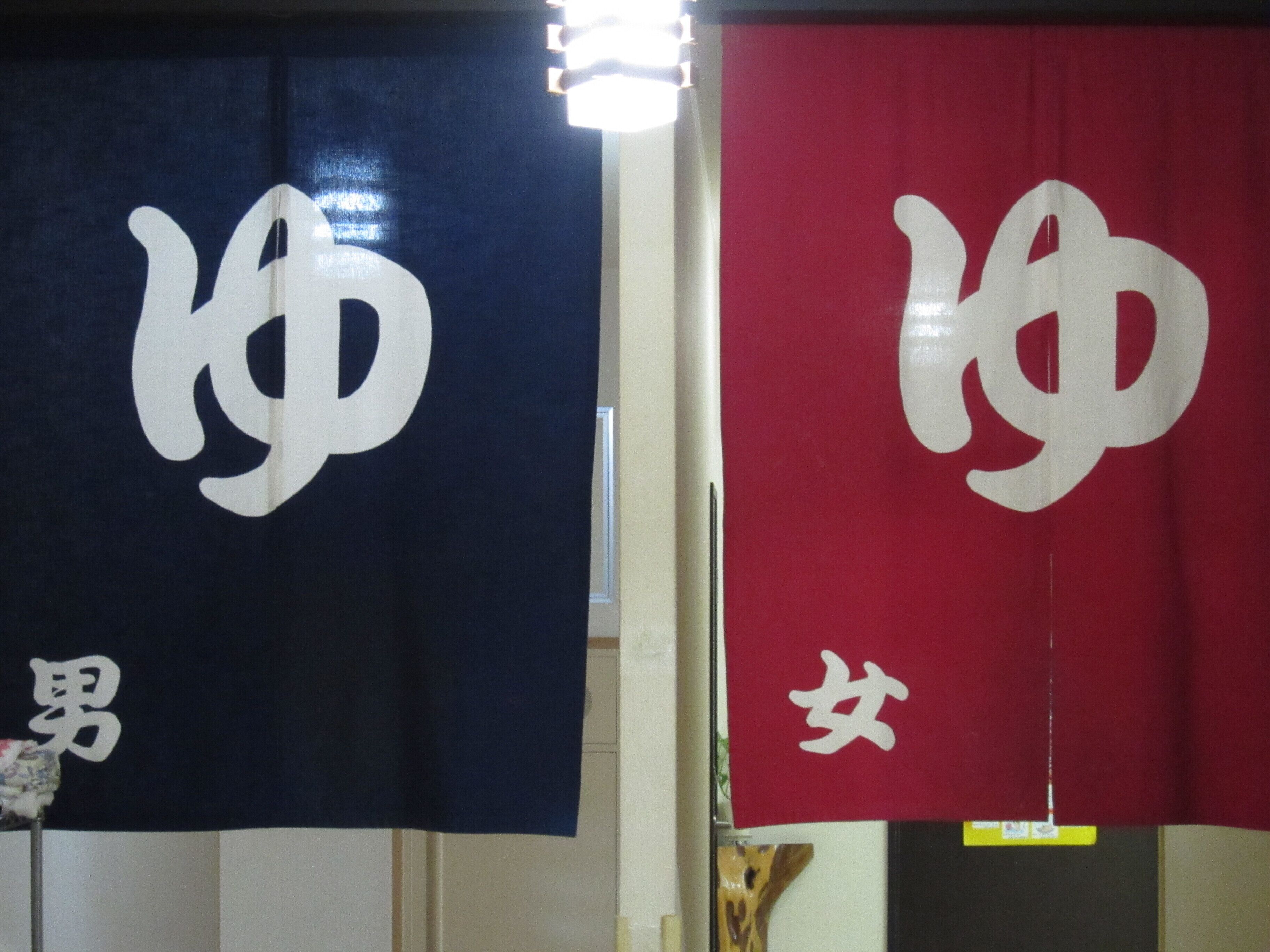 Two banners with large white characters hanging in a room.