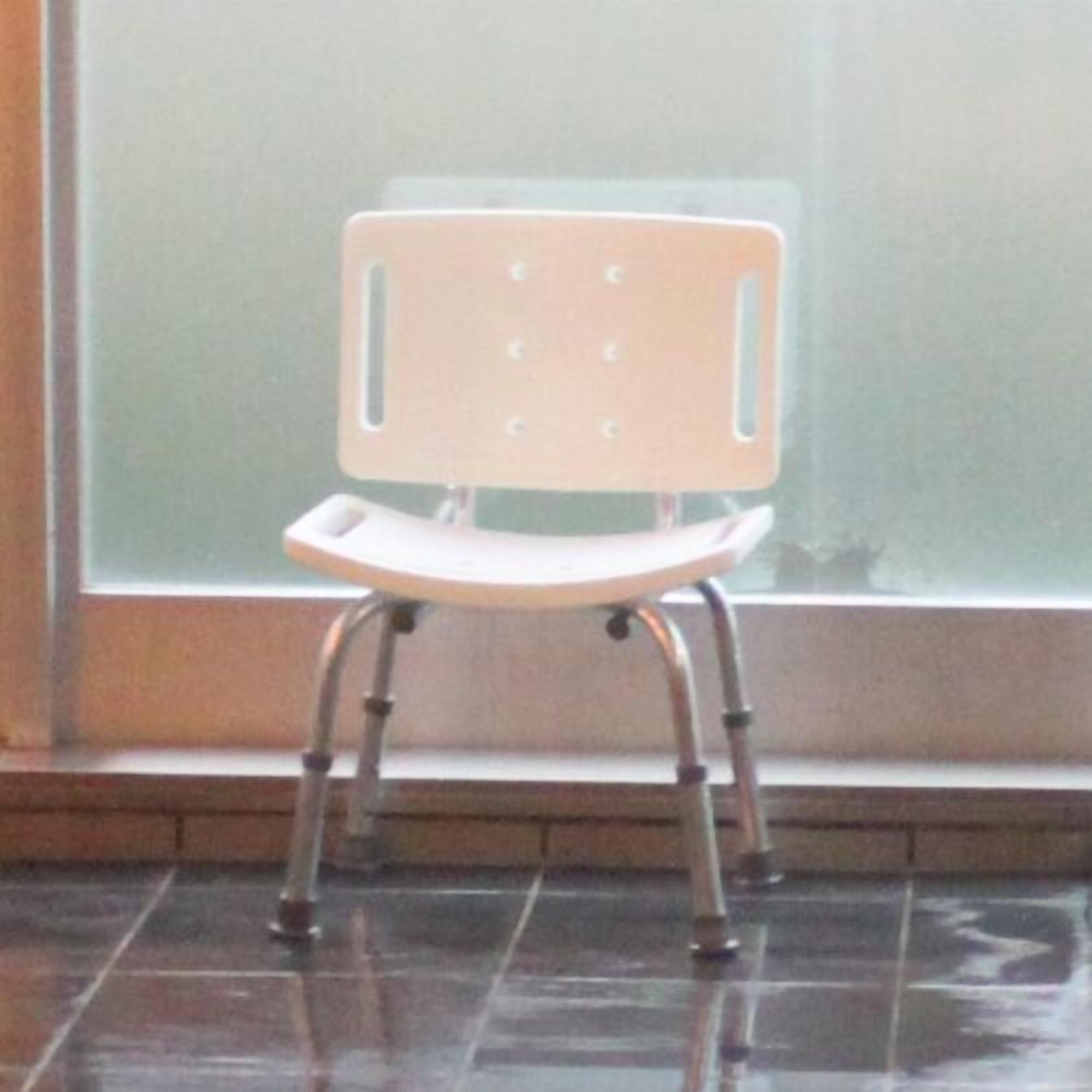 A chair with a backrest and armrests, positioned in front of a window.