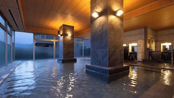 Amplio espacio interior con piso húmedo, pilares grandes y un diseño moderno.