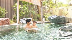 Una piscina con agua cristalina, rodeada de rocas y follaje.
