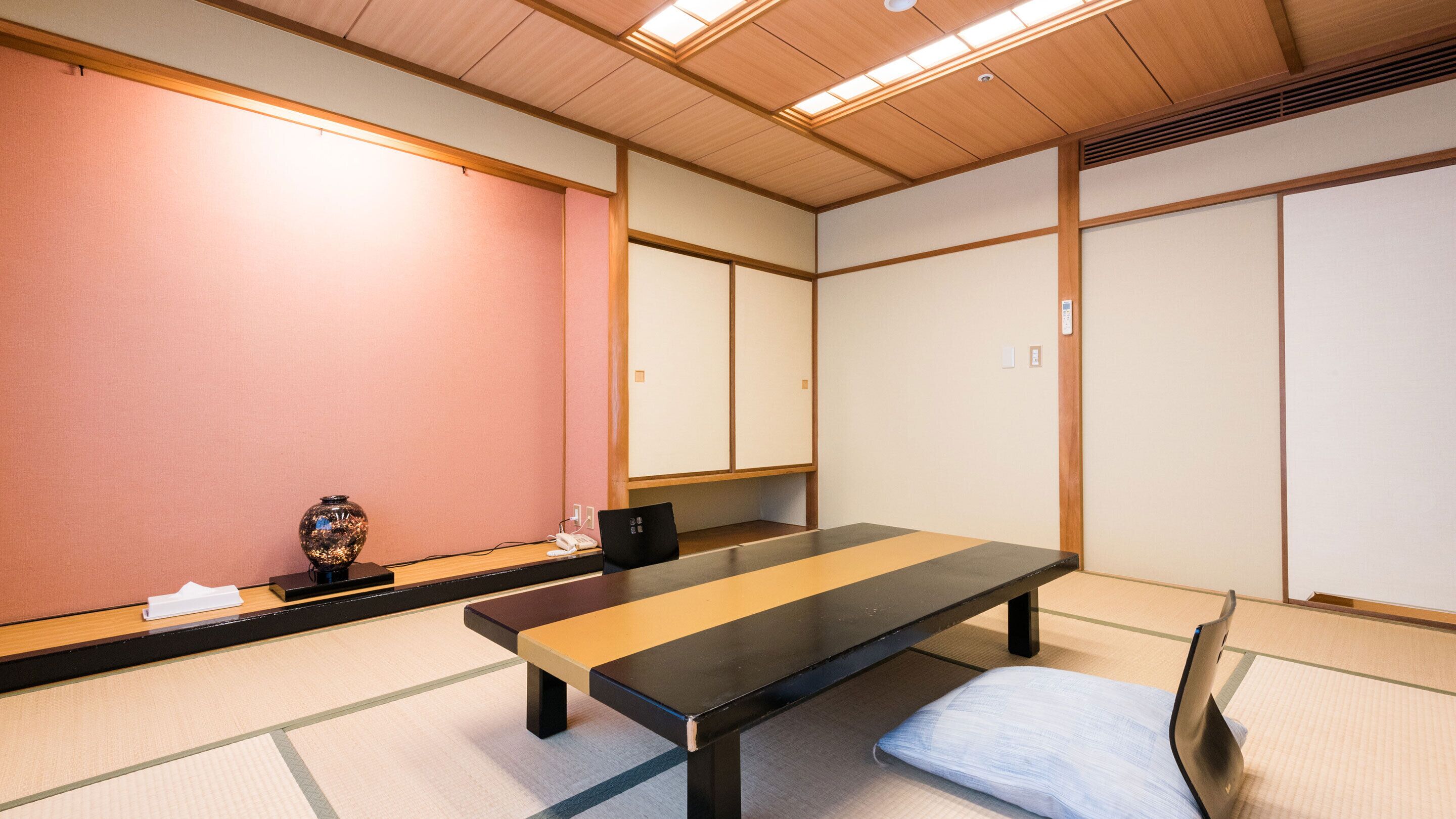 A traditional Japanese tatami room with a low table and a cushion.
