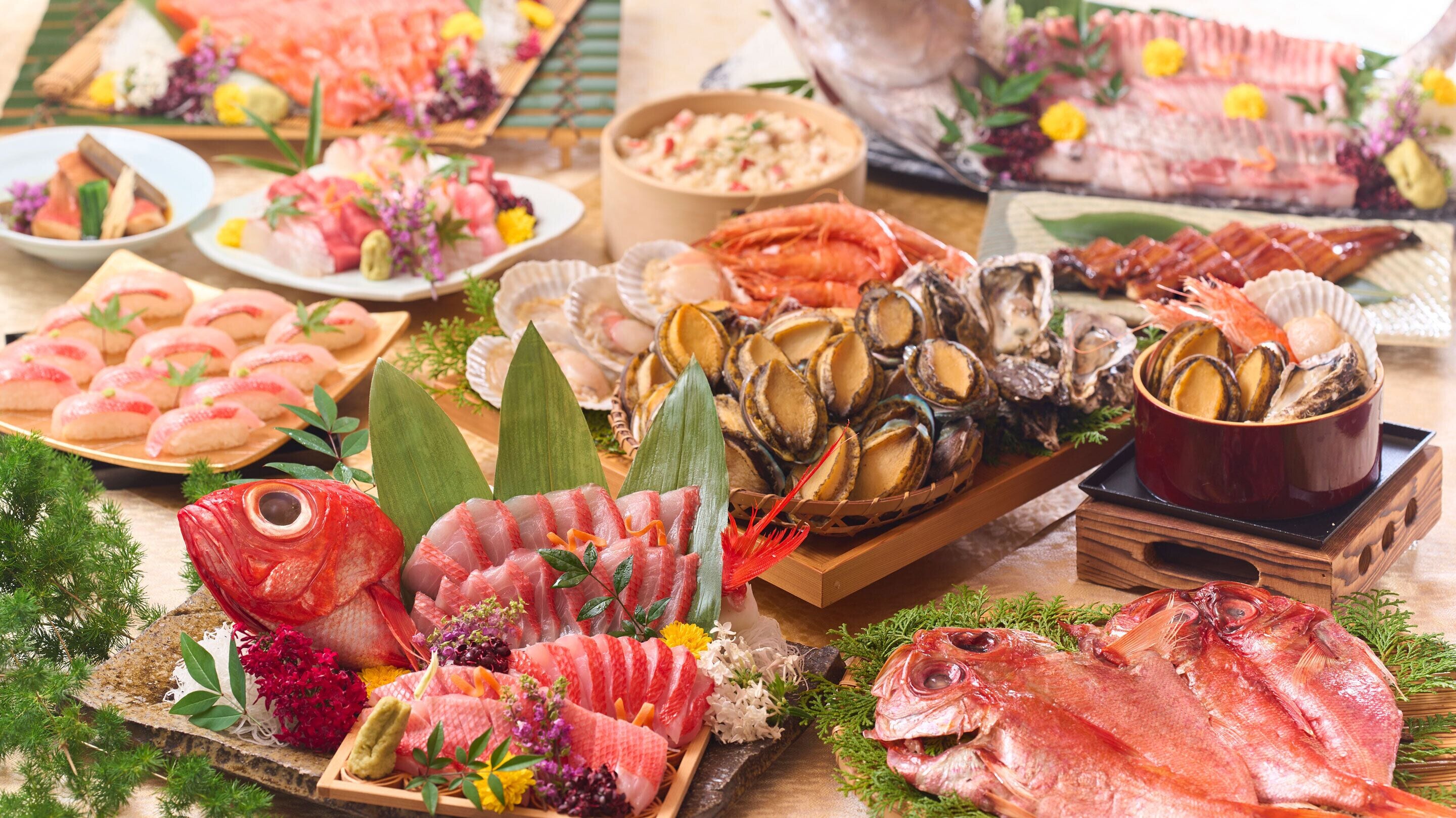 A variety of seafood including fish, shrimp, and oysters displayed on a wooden table with decorative elements.