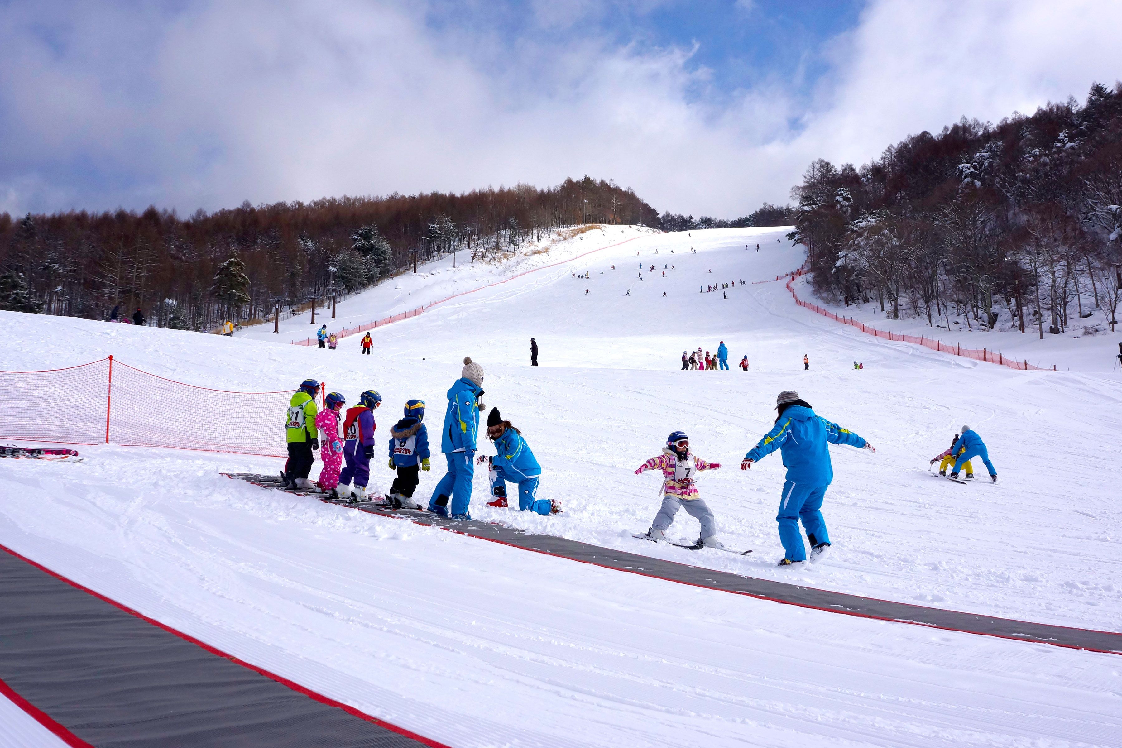 Pista de esqui coberta de neve, com esquiadores e snowboarders.