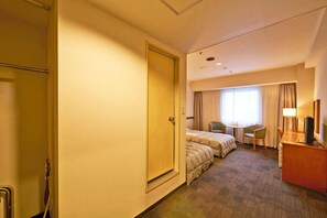 A hotel room with a bed, two chairs, a desk, and a window with curtains. - Ageo Tobu Hotel (Ageo)