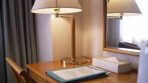 A hotel room with a wooden desk, two lamps, a mirror, a tissue box, a tray with a cup and a menu. - Ageo Tobu Hotel (Ageo)