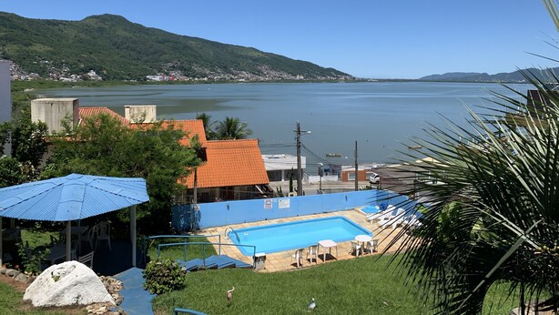 Vue d'un espace piscine avec, en arrière-plan, un lac et des montagnes.