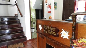 Un comptoir d’accueil avec une pancarte sur laquelle on peut lire : « Vous êtes spécial, bienvenue chez nous », et un escalier menant à l’étage supérieur.