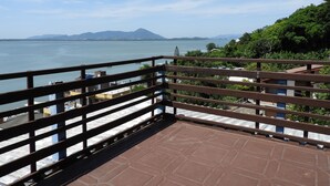 Une terrasse offrant une vue sur un plan d’eau et sur des montagnes lointaines.