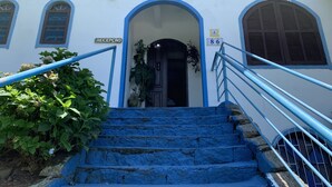 L’entrée d’un immeuble, avec une enseigne indiquant « Hôtel Edelweiss » et un panneau indiquant la réception.