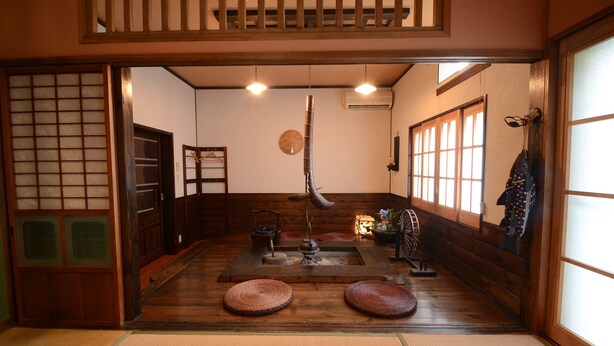 A traditional Japanese room with tatami flooring, a shoji screen, a hanging fish decoration, and a low table with a tea set. - Shikisai no Sato Manyuu (Kirishima)