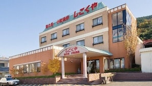 A multi-story building with a sign indicating it is a hotel. There is a covered entrance with a sign above it. - Shikokuya (Saijo)