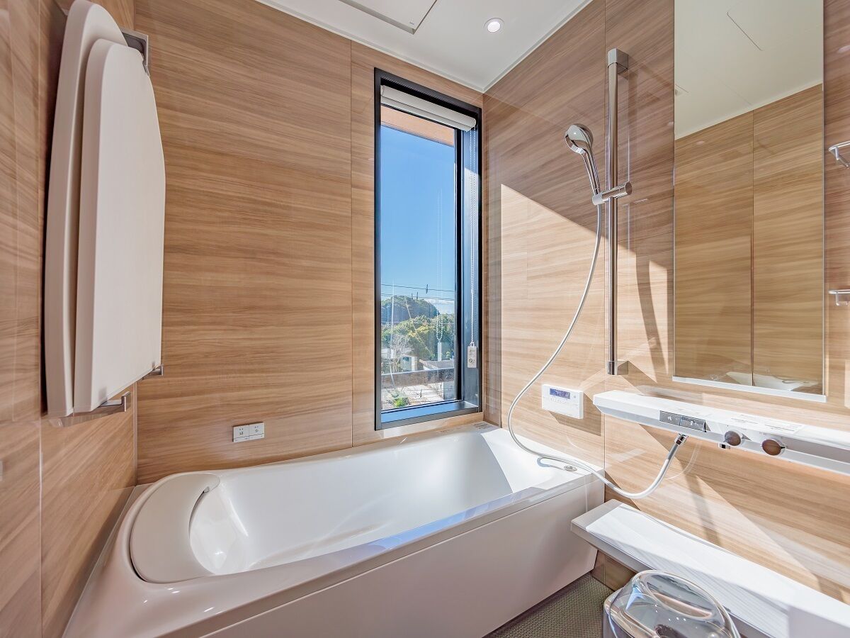 Un baño moderno con bañera, ventana y ducha.