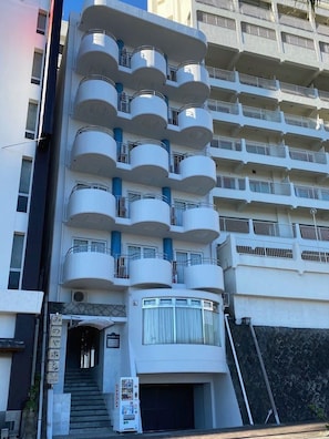 A multi-story hotel with balconies, a staircase, and a vending machine. - Atami Minoya Hotel (Atami)