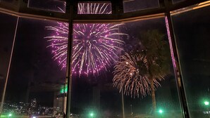 A view from inside a building with large windows, looking out at a cityscape with buildings and a body of water. - Atami Minoya Hotel (Atami)