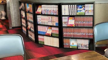 A library with bookshelves filled with manga and anime magazines.