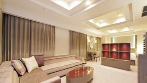 A modern hotel room with a sofa, a coffee table, a desk, and a shelving unit. - Kusatsu Estopia Hotel (Kusatsu (Shiga))
