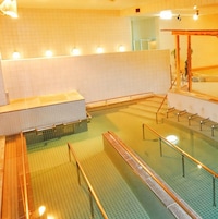 A swimming pool with multiple lanes, a changing room area, and a seating area with a wooden structure.