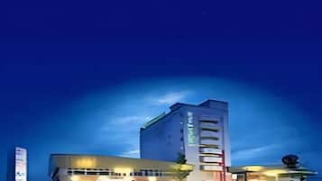 A multi-story hotel with a modern architectural design, featuring a prominent vertical element on the facade.