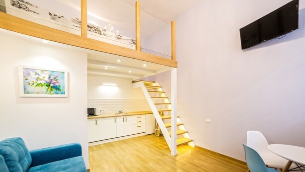 A modern apartment with a kitchen, dining area, and a staircase leading to an upper level. - Apartments 1 min to Opera House (Lviv)