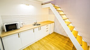 A compact kitchen with a microwave, sink, and wooden countertop. - Apartments 1 min to Opera House (Lviv)