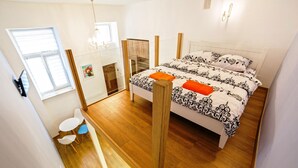 A bedroom with a bed, a small table, and chairs. - Apartments 1 min to Opera House (Lviv)