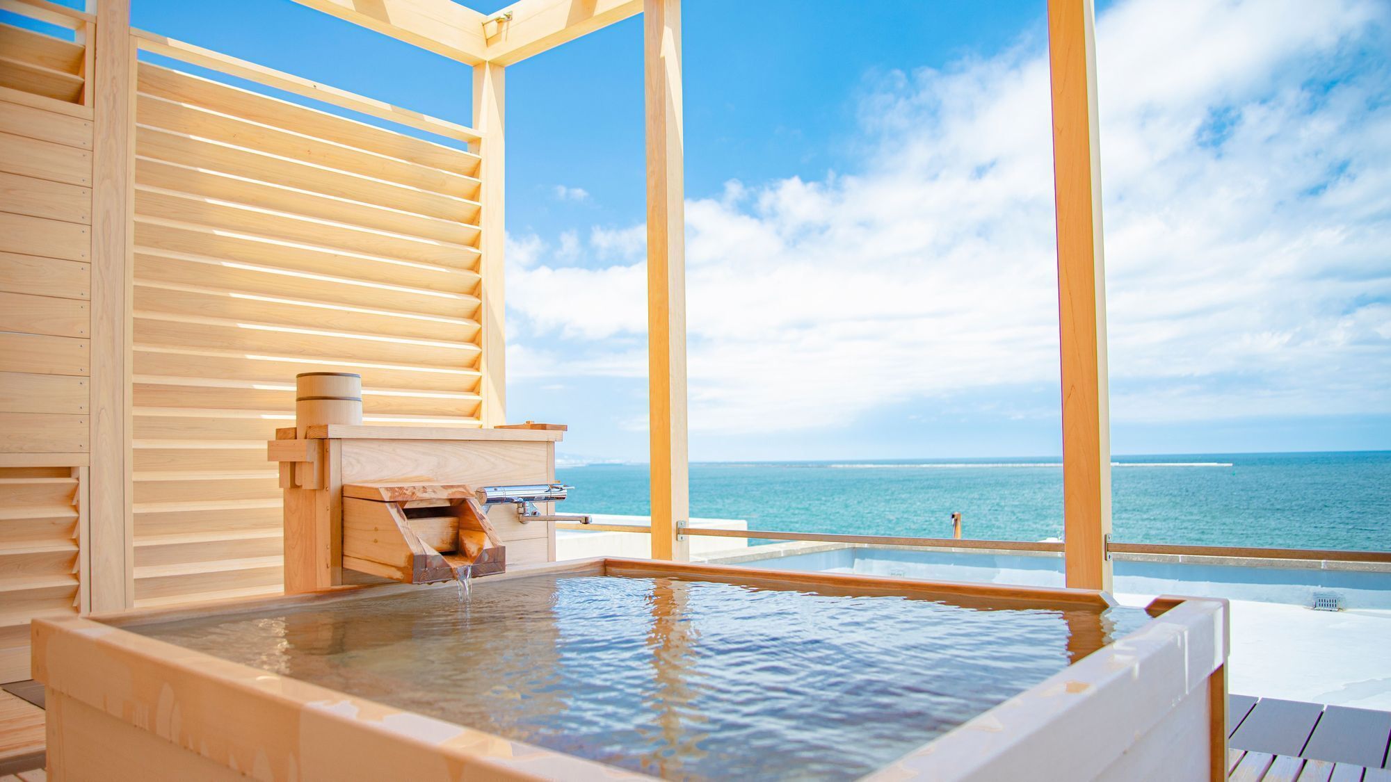 A wooden spa with a hot tub and a view of the ocean.
