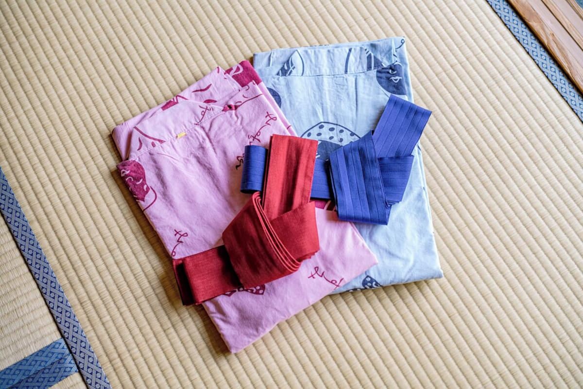 Un futón de tatami con textiles doblados y un marco de madera.