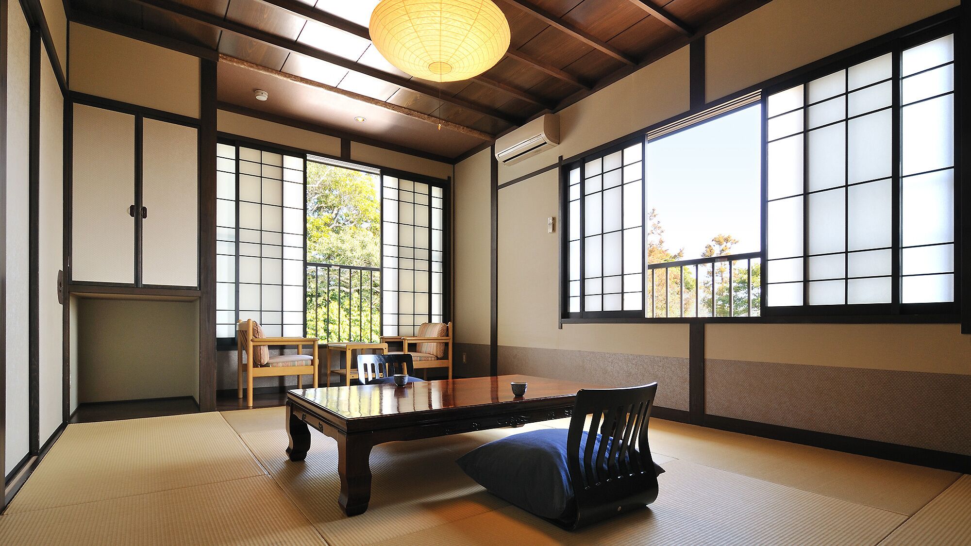 Um quarto japonês tradicional com piso de tatame, uma mesa baixa e portas deslizantes shoji.