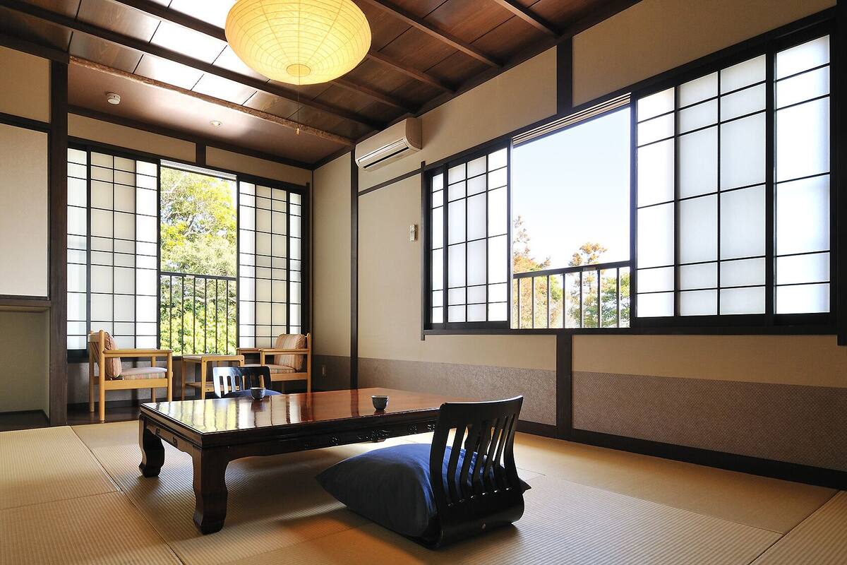 A traditional Japanese room with tatami flooring, a low table, and sliding shoji doors.