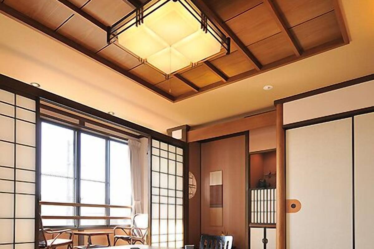A traditional Japanese-style room with tatami flooring, a low table, and sliding doors.