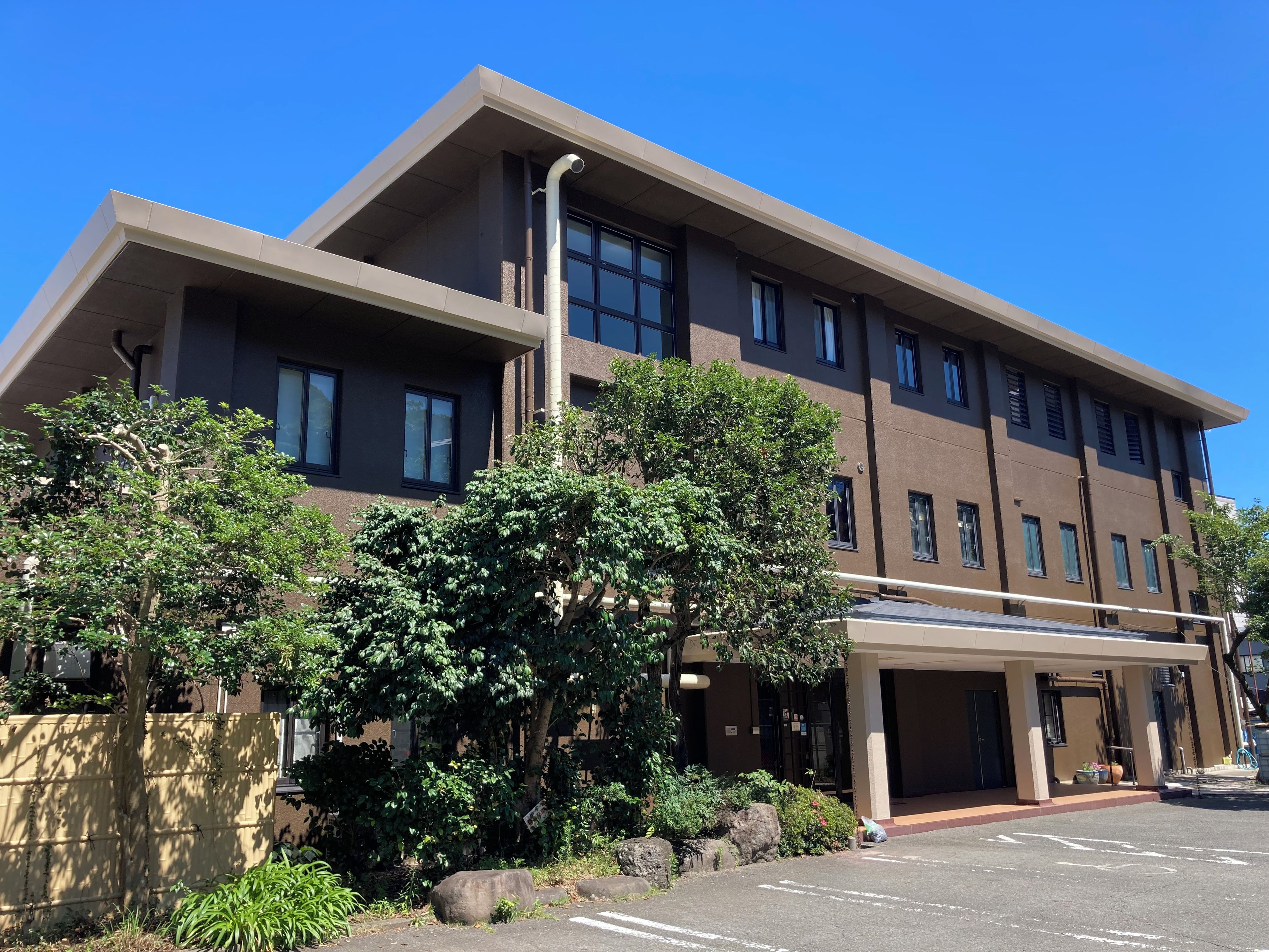 Monikerroksinen rakennus, jossa on tasakatto, suuret ikkunat ja katettu sisäänkäyntialue.