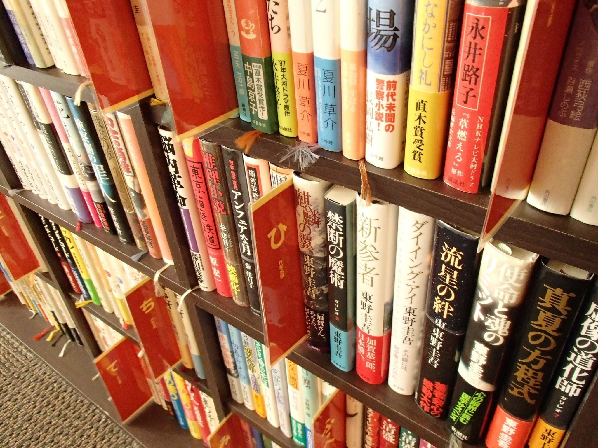 A bookshelf with various books, some with visible titles and authors.