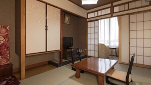 A traditional Japanese room with tatami flooring, a low table, and sliding doors. - Izu Nagaoka Onsen Kkr Izu Nagaoka Chitoseso (Izunokuni)