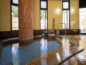 A hot tub area with a tiled floor, a brick pillar, and a window with blinds. - Izu Nagaoka Onsen Kkr Izu Nagaoka Chitoseso (Izunokuni)
