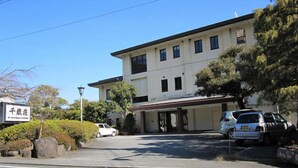 A two-story building with a flat roof, a signboard, and parked cars in front. - Izu Nagaoka Onsen Kkr Izu Nagaoka Chitoseso (Izunokuni)
