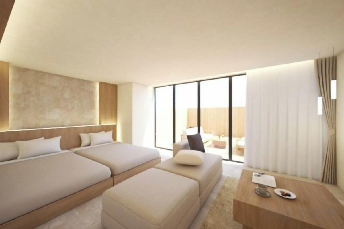 A hotel room with a large bed, a desk, and a view of the outdoors.