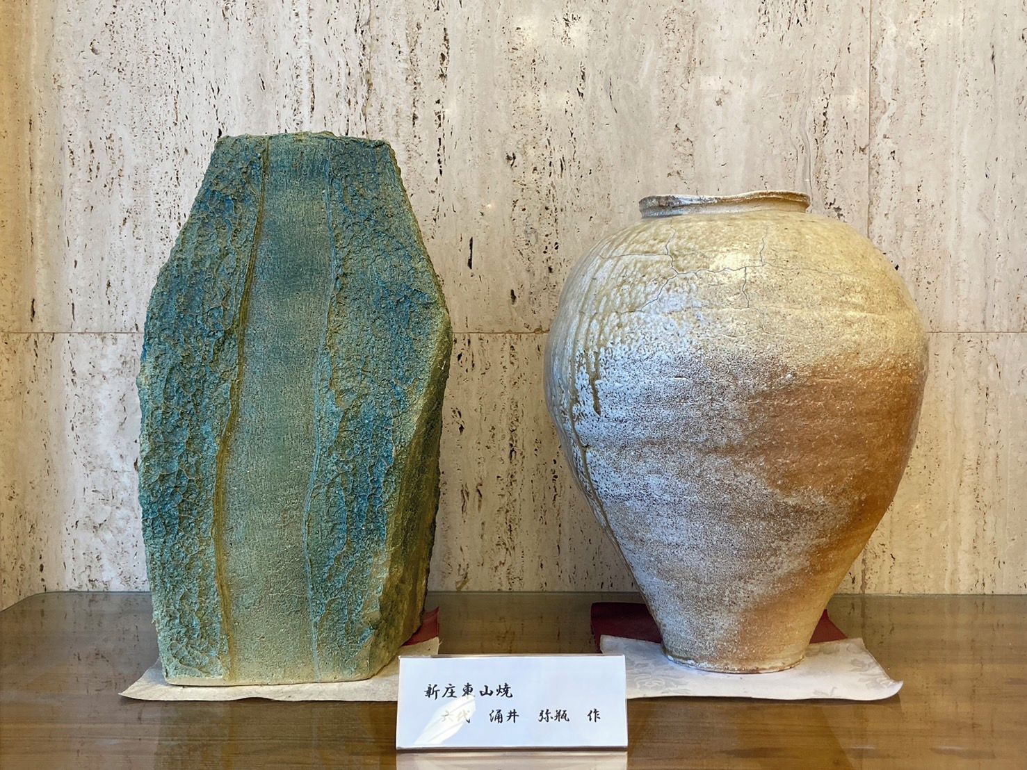 Two ceramic vases on display with a label in front.
