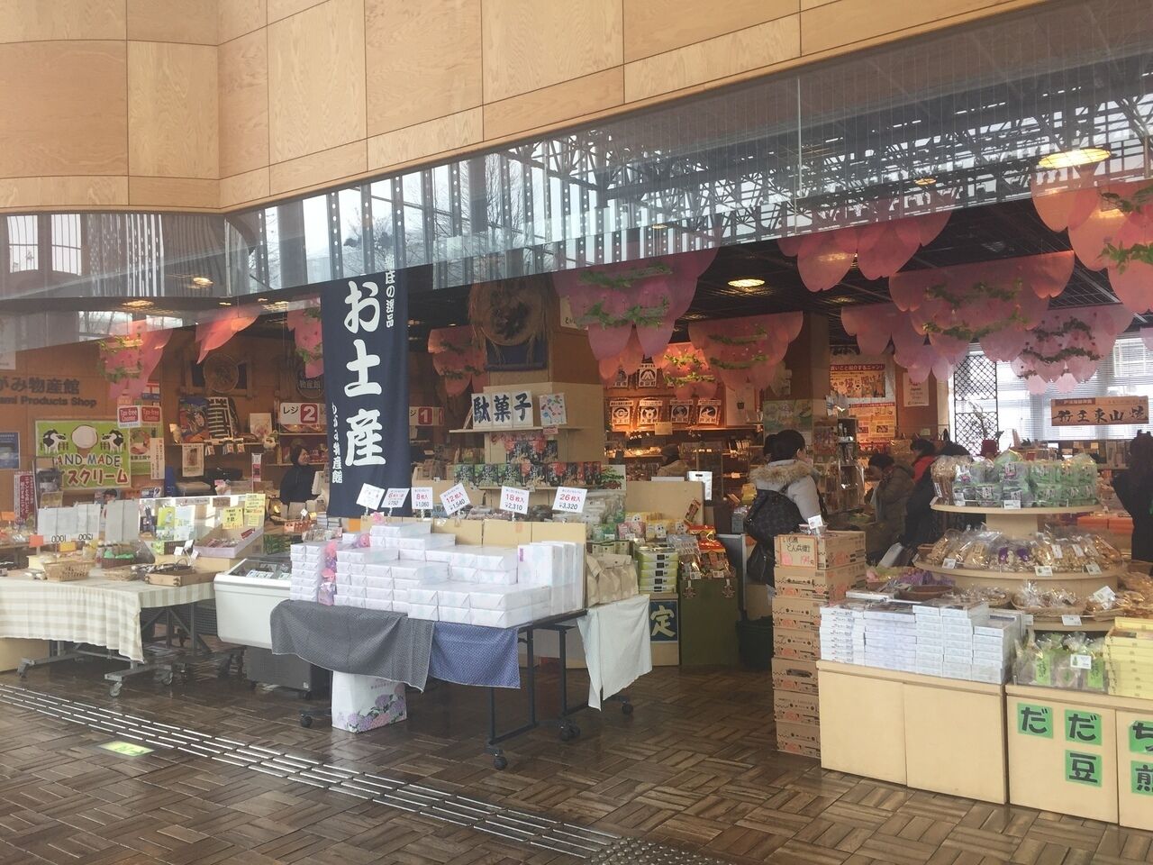 A market stall with various goods on display, a sign with Japanese text, and a person in the background.