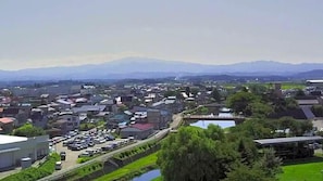 A town with a mix of residential and commercial buildings, a parking lot, and a bridge over a water body.