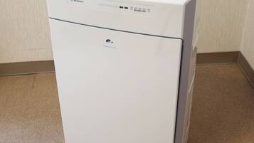 A white Panasonic F-VX40H2 air purifier in a corner with a beige carpet.