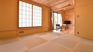 A tatami mat room with a sliding door, a television, and a small table with chairs. - Itamuro Onsen Okunasu Taishomura Sachinoyu Onsen (Nasushiobara)